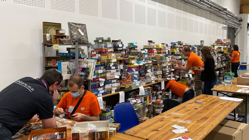 Stand du dépôt-vente Ludoccasion avant l'ouverture du festival présentant des centaines de boîtes de eux de société étiquettées et rangées